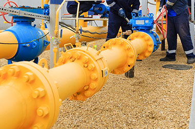 professionals performing maintenance on a yellow gas pipeline