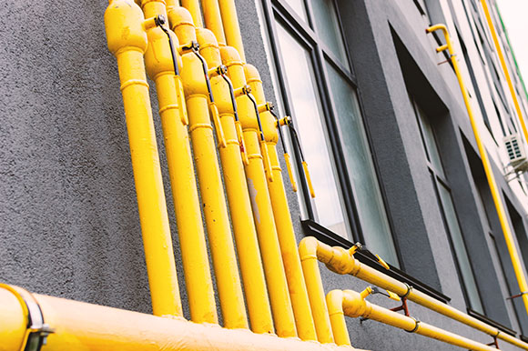 yellow gas pipes newly installed vertically on a building